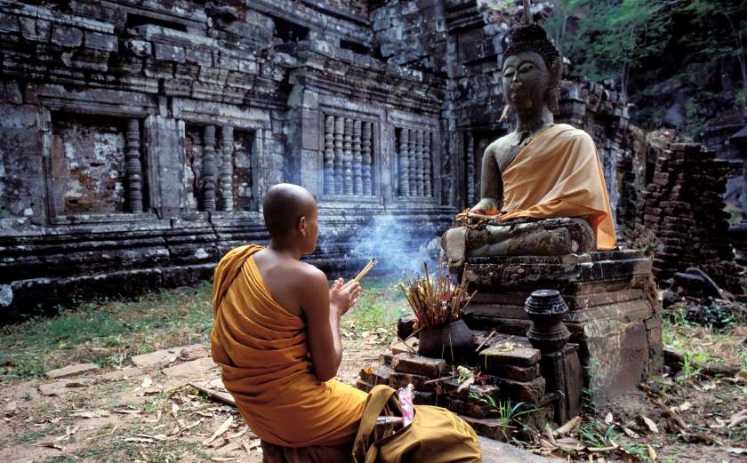 Moine Laotien priant dans un temple boudhiste