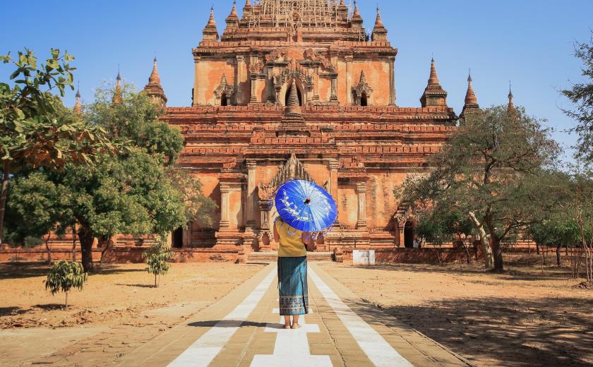 Femme birmane de dos en tenue traditionnelle devant un temple sur le site de Bagan