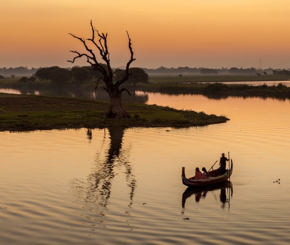 Bateau traversant le lac de Taunghaman au coucher de soleil