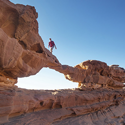Voyageur marchant sur stobe bridge arch dans le désert de Wadi Rum
